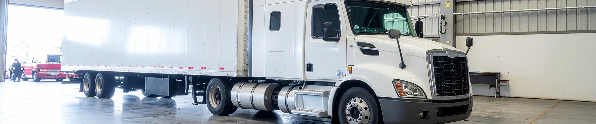 A white Volvo box truck in the bay.